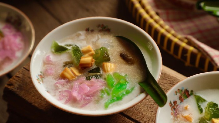 Es Dawet, or also popularly known as Es Cendol, a Javanese icy dessert of rice noodle jelly in coconut milk soup sweetened with coconut brown sugar that has been infused with jackfruit. In this version, the rice noodle is made into three colors instead of just the usual green one. Then cooling green grass jelly is also added to the mixture. The dish is served in old-fashioned ceramic bowls.