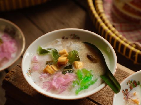 Es Dawet, or also popularly known as Es Cendol, a Javanese icy dessert of rice noodle jelly in coconut milk soup sweetened with coconut brown sugar that has been infused with jackfruit. In this version, the rice noodle is made into three colors instead of just the usual green one. Then cooling green grass jelly is also added to the mixture. The dish is served in old-fashioned ceramic bowls.