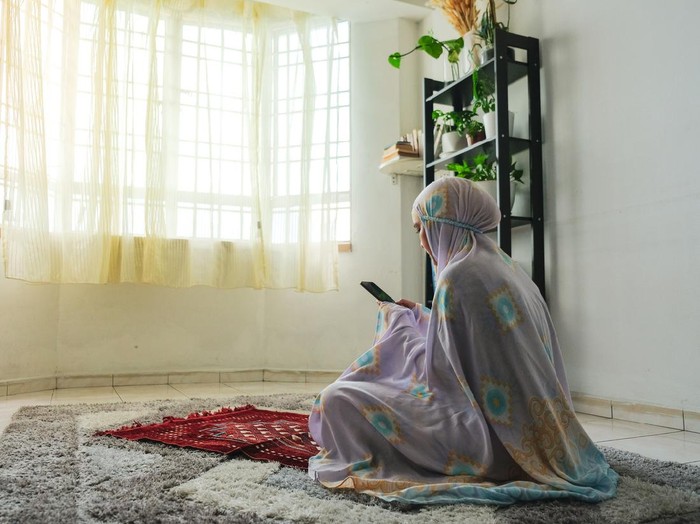 Muslim family using mobile at home during ramadhan