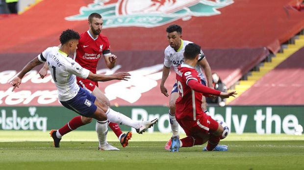 Aston Villa's Ollie Watkins, left, scores his side's opening goal during the English Premier League soccer match between Liverpool and Aston Villa at Anfield stadium in Liverpool, England, Saturday, April 10, 2021. (Clive Brunskill/Pool via AP)