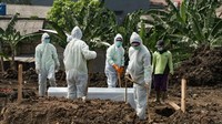Foto: Pemakaman berlangsung dengan protokol COVID-19. Petugas mengenakan APD hazmat dan jenazah dimasukkan ke dalam peti mati (Andhika Prasetia/detikcom)
