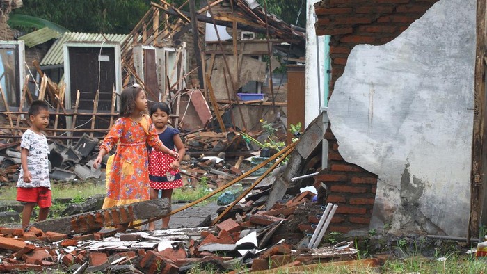 KERUSAKAN AKIBAT GEMPA DI MALANG Seorang warga menelepon di depan rumahnya yang hancur akibat gempa di Majangtengah, Malang, Jawa Timur, Minggu (11/4/2021). Badan Nasional Penanggulangan Bencana (BNPB) melaporkan sedikitnya 1.189 unit rumah rusak akibat gempa bermagnitudo 6,1 yang mengguncang kawasan Malang dan sekitarnya. ANTARA FOTO/Ari Bowo Sucipto/rwa.