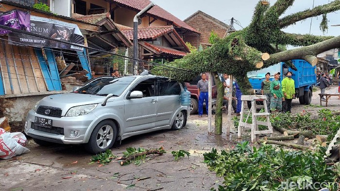 Mobil rusak tertimpa pohon tumbang di Bandung.
