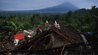 Warga menyelamatkan barang berharga dari reruntuhan rumah mereka yang rusak akibat diguncang gempa.