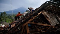Warga mengumpulkan barang berharga miliknya di antara reruntuhan rumah yang rubuh akibat gempa di Desa Kali Uling, Lumajang, Jawa Timur, Minggu (11/4/2021). 