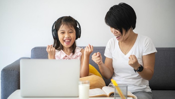 Asian girl and her teacher using laptop for online study during homeschooling at home during Coronavirus or Covid-19 virus outbreak situation