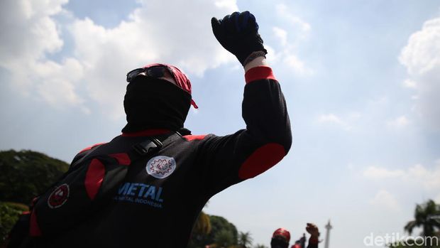 Sejumlah buruh melakukan aksi unjuk rasa di Patung Kuda, Monas, Jakarta, Senin (12/4/2021).  Puluhan buruh yang tergabung dalam Konfederasi Serikat Pekerja Indonesia (KSPI) hari ini menggelar aksi untuk menyampaikan tuntutan di patung kuda dan Mahkamah Konstitusi (MK).