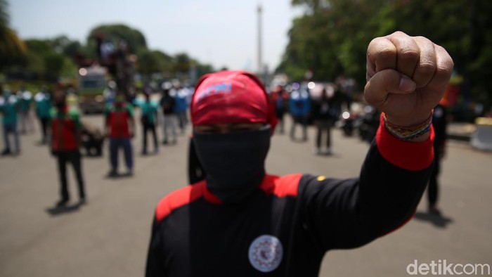 Sejumlah buruh melakukan aksi unjuk rasa di Patung Kuda, Monas, Jakarta, Senin (12/4/2021).  Puluhan buruh yang tergabung dalam Konfederasi Serikat Pekerja Indonesia (KSPI) hari ini menggelar aksi untuk menyampaikan tuntutan di patung kuda dan Mahkamah Konstitusi (MK).