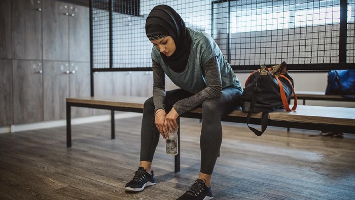 fitness Young woman in dressing room after hard training in gym. Wearing sports clothing and hijab.