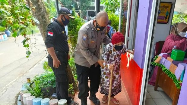 Polisi di Tangsel membantu lansia yang akan mendapatkan vaksin COVID-19. Foto dikirim Kasat Reskrim Polres Tangsel AKP Angga Surya Saputra