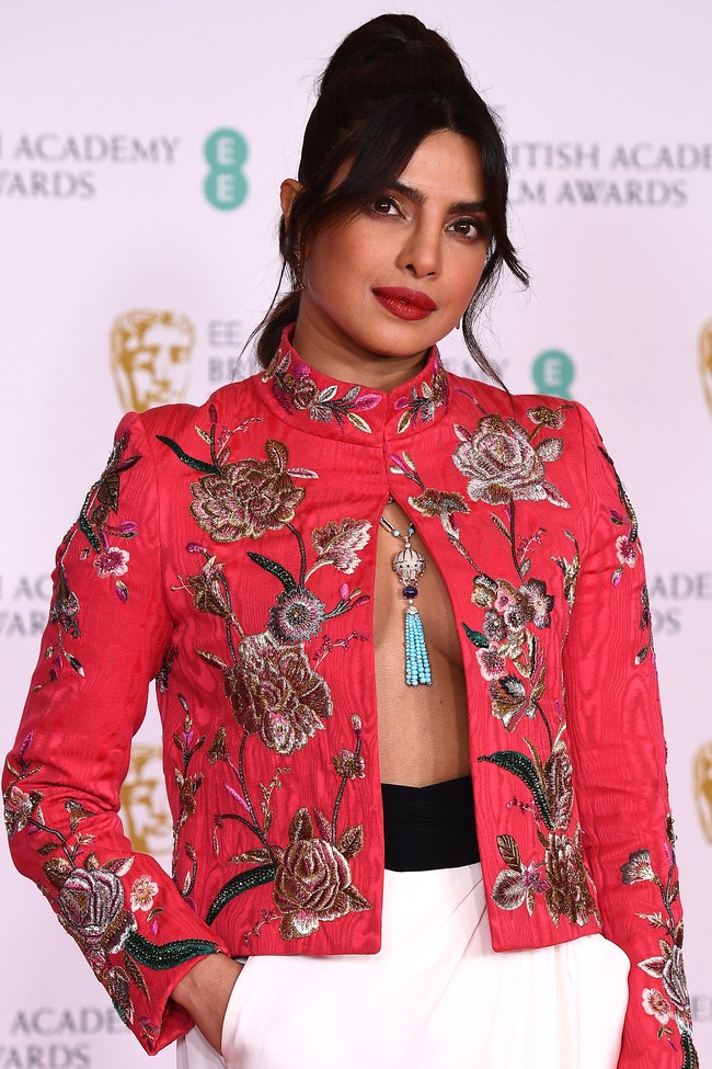 Baju keluaran label Pertegaz ini hadir dengan gaya kerah  tinggi yang terkancing, lalu dibiarkan terbuka pada bagian bawah sehingga mengekspos area dadanya yang tanpa dalaman (braless). (Foto: Getty Images/Jeff Spicer)