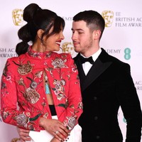 Celana putih bergaya jodhpurs ia pilih sebagai bawahan dengan padanan heels hitam Christian Louboutin. Tak ketinggalan, sebuah kalung statement bergaya etnik dengan detail beading berwarna turquoise. (Foto: Getty Images/Jeff Spicer)