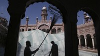 Relawan membersihkan area luar Masjid Mohabat Khan yang bersejarah menjelang bulan puasa Ramadhan di Peshawar, Pakistan. AP Photo/Muhammad Sajjad  