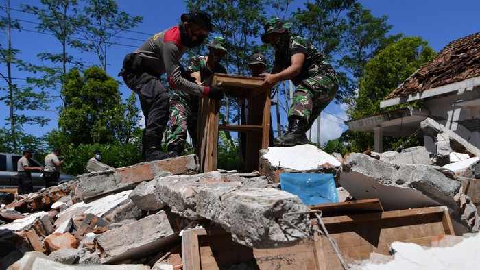 TNI POLRI BANTU WARGA KORBAN GEMPA Sejumlah prajurit TNI AD membantu warga membersihkan puing-puing bangunan yang rusak akibat gempa di Desa Kaliuling, Lumajang, Jawa Timur, Senin (12/4/2021). Personel TNI dan Polri dikerahkan untuk membantu warga korban gempa untuk membersihkan sisa-sisa puing bangunan yang rusak akibat gempa. ANTARA FOTO/Zabur Karuru/foc.