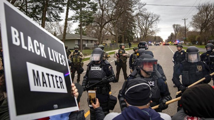 Protesters clash with police in front of the Brooklyn Center Police station on Sunday, April 11, 2021, in Brooklyn Center, Minn. The family of Daunte Wright, 20, told a crowd that he was shot by police Sunday before getting back into his car and driving away, then crashing the vehicle several blocks away. The family said Wright was later pronounced dead. (AP Photo/Christian Monterrosa)