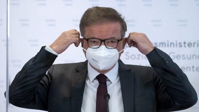 Austrias Health Minister Rudolf Anschober takes off his face mask as he arrives to address a press conference on April 13, 2021 in Vienna, amid the novel coronavirus / COVID-19 pandemic. - Anschober announced that he would resign, saying managing the coronavirus crisis had overworked him. (Photo by JOE KLAMAR / AFP)