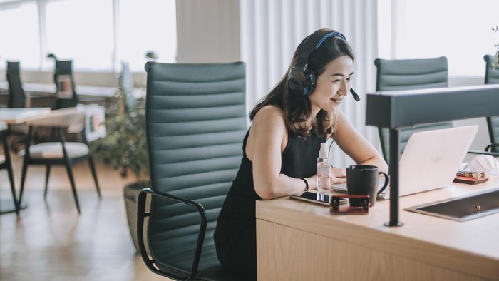 an asian chinese mid adult white collar worker talking to the camera video calling video conference with his business partners  with face mask