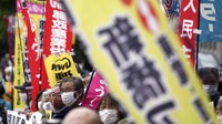Orang-orang meneriakkan slogan-slogan menentang keputusan pemerintah untuk mulai melepaskan sejumlah besar air radioaktif yang diolah dari pembangkit nuklir Fukushima yang rusak ke laut, di luar kantor perdana menteri, Tokyo, Jepang, Selasa (13/4/2021) waktu setempat. AP Photo/Eugene Hoshiko  