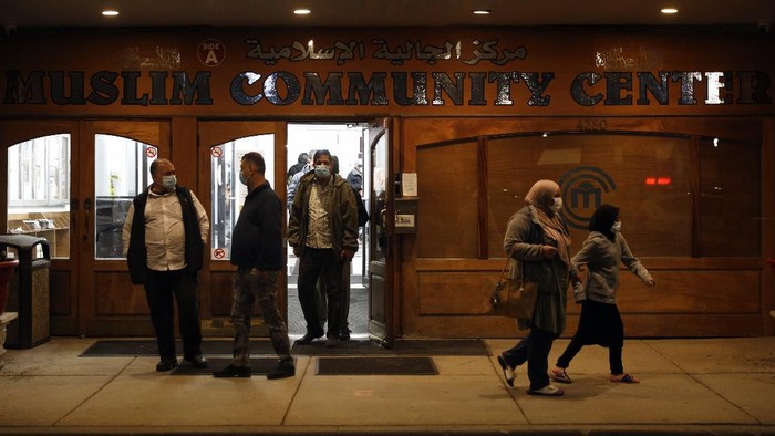 A Muslim makes a donation after an evening prayer called 
