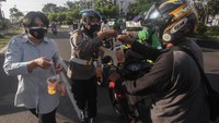 Personel Polwan Provos Polda Kalteng membagikan takjil kepada pengendara di Jalan Tjilik Riwut, Palangkaraya, Kalimantan Tengah, Selasa (13/4/2021). Aksi bagi takjil gratis tersebut diinisiasi oleh Yayasan Kemala Bhayangkari daerah Kalteng sebagai wujud kepedulian kepada pengendara khususnya umat muslim yang menjalankan ibadah puasa. ANTARA FOTO/Makna Zaezar.