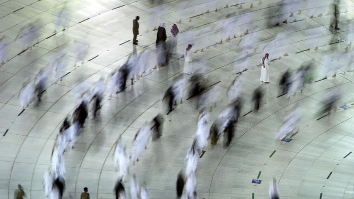 Muslim pilgrims pray around the Kaaba, the cubic building at the Grand Mosque, as they keep social distancing during the minor pilgrimage, known as Umrah, marking the holy month of Ramadan, in the Muslim holy city of Mecca, Saudi Arabia, Monday, April 12, 2021. During Ramadan, the holiest month in Islamic calendar, Muslims refrain from eating, drinking, smoking and sex from dawn to dusk. (AP Photo/Amr Nabil)