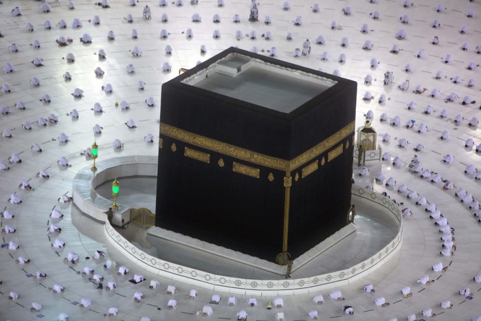 Muslim pilgrims pray around the Kaaba, the cubic building at the Grand Mosque, as they keep social distancing during the minor pilgrimage, known as Umrah, marking the holy month of Ramadan, in the Muslim holy city of Mecca, Saudi Arabia, Monday, April 12, 2021. During Ramadan, the holiest month in Islamic calendar, Muslims refrain from eating, drinking, smoking and sex from dawn to dusk. (AP Photo/Amr Nabil)