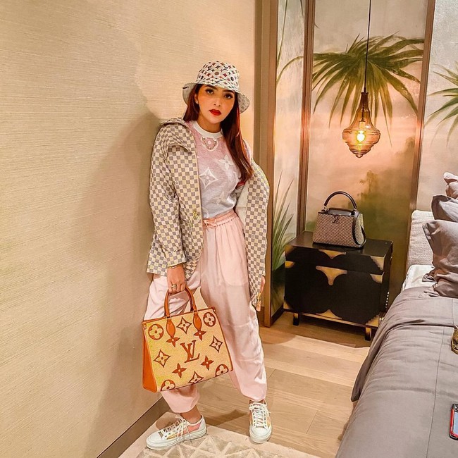 Ashanty pun tak absen dari acara yang digelar baru-baru ini. Ibu tiri Aurel Hermansyah itu bersolek dengan busana bergaya sporty dalam nuansa pastel yang dibungkus coat putih motif monogram dan bucket hat senada. Tak ketinggalan tote bag LV dan sneakers.  (Foto: Instagram)