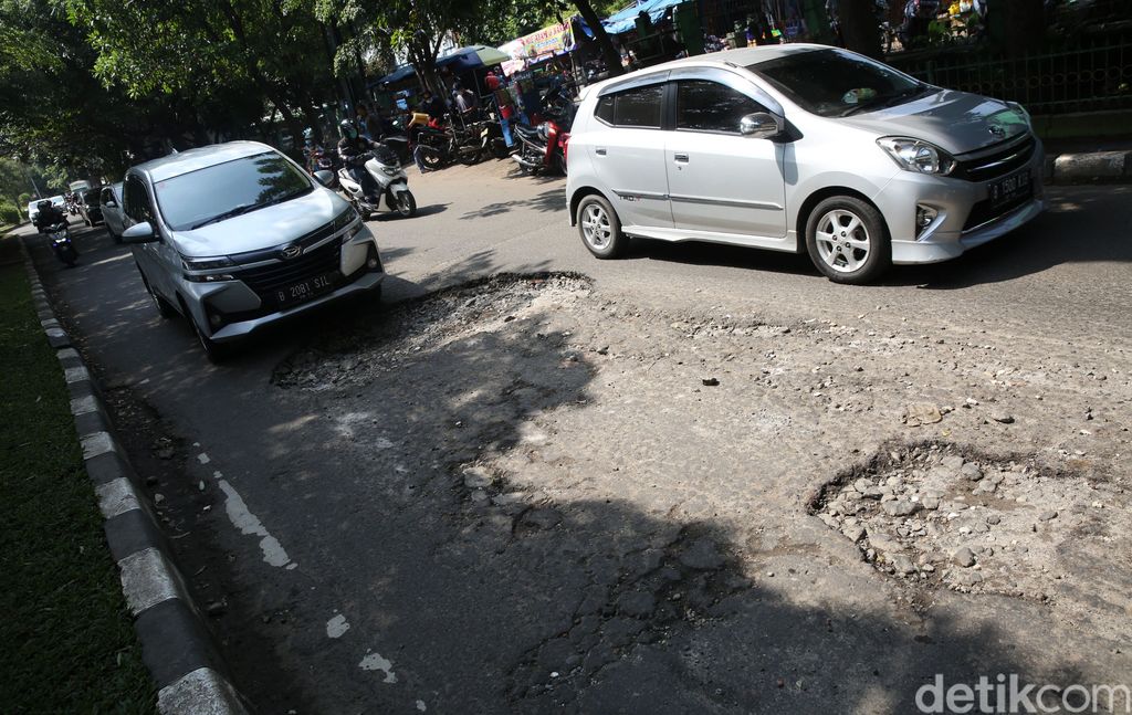 Pengendara mengindari jalan rusak di Jalan I Gusti Ngurah Rai Bekasi arah Jakarta depan Stasiun Cakung Kota Bekasi, Jawa Barat, Rabu (14/4/2021). Jalan rusak dikawasan ini sudah berlangsung beberapa bulan akibat buruknya drainase dan terandam genangan saat hujan.