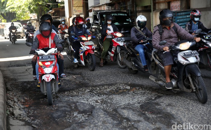 Pengendara mengindari jalan rusak di Jalan I Gusti Ngurah Rai Bekasi arah Jakarta depan Stasiun Cakung Kota Bekasi, Jawa Barat, Rabu (14/4/2021). Jalan rusak dikawasan ini sudah berlangsung beberapa bulan akibat buruknya drainase dan terandam genangan saat hujan.