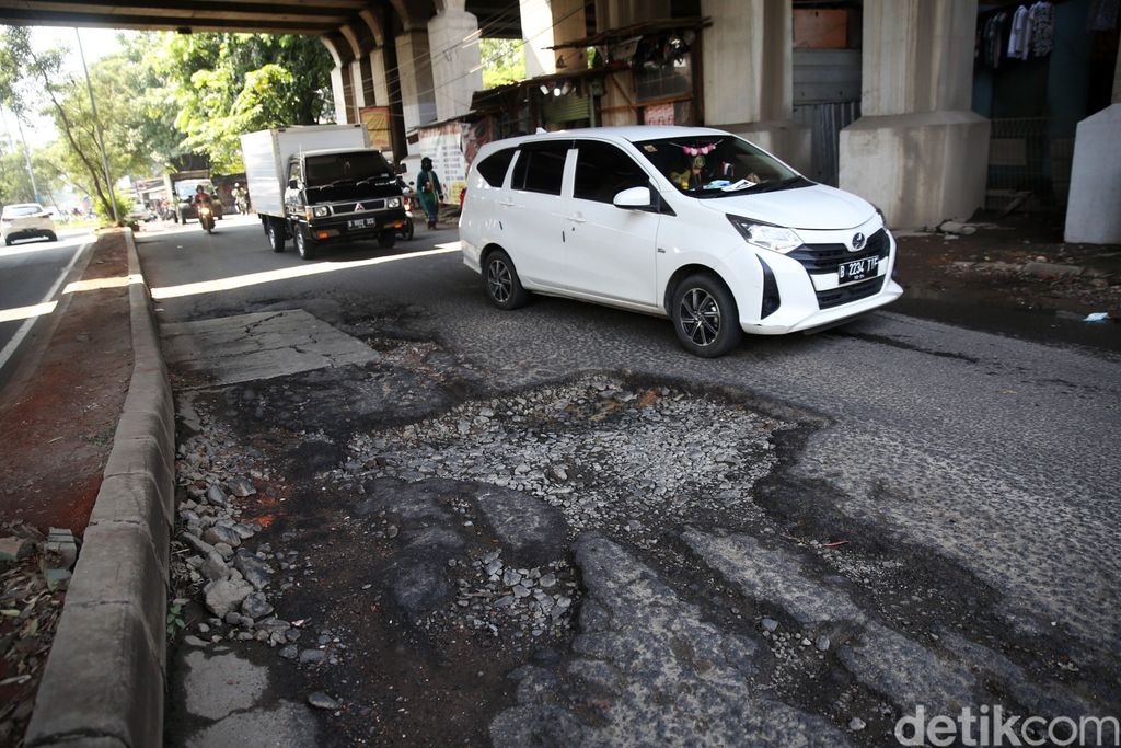 Pengendara mengindari jalan rusak di Jalan I Gusti Ngurah Rai Bekasi arah Jakarta depan Stasiun Cakung Kota Bekasi, Jawa Barat, Rabu (14/4/2021). Jalan rusak dikawasan ini sudah berlangsung beberapa bulan akibat buruknya drainase dan terandam genangan saat hujan.