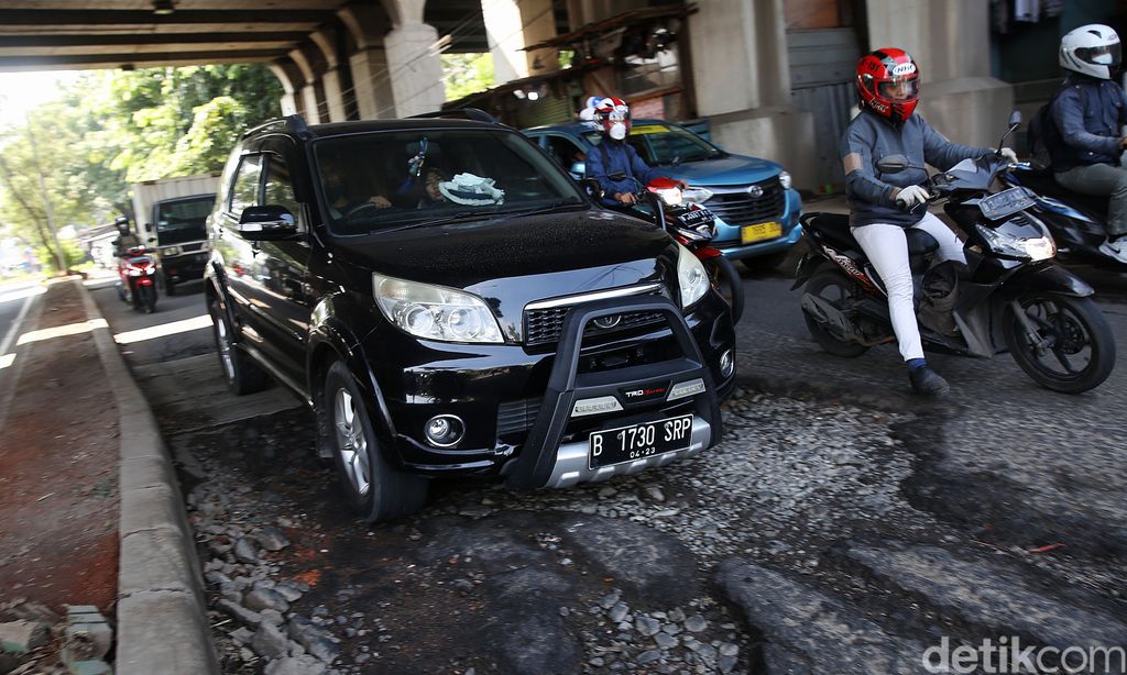 Pengendara mengindari jalan rusak di Jalan I Gusti Ngurah Rai Bekasi arah Jakarta depan Stasiun Cakung Kota Bekasi, Jawa Barat, Rabu (14/4/2021). Jalan rusak dikawasan ini sudah berlangsung beberapa bulan akibat buruknya drainase dan terandam genangan saat hujan.