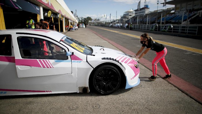 Vitarti Girl’s Team driver Rocio Migliore, back to camera, arrives at pits and is embraced by friends to celebrate her second-place finish at the Oscar y Juan Galvez track in Buenos Aires, Argentina, Sunday, April 4, 2021. The racing team exclusive to females took part in the Top Race Junior series, a national competition, in Argentina for the first time. (AP Photo/Natacha Pisarenko)