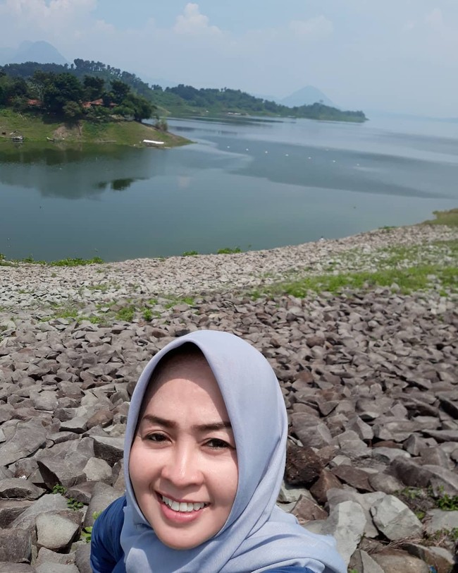 Maryati terlihat mengunggah momen selfie ketika mengunjungi Waduk Jati Luhur di Kabupaten Purwakarta, Provinsi Jawa Barat. Ia memakai hijab segi empat warna abu-abu dan atasan warna biru. Wajahnya terlihat cerah dan glowing.  Foto: dok. Instagram @maryati.tohirr.