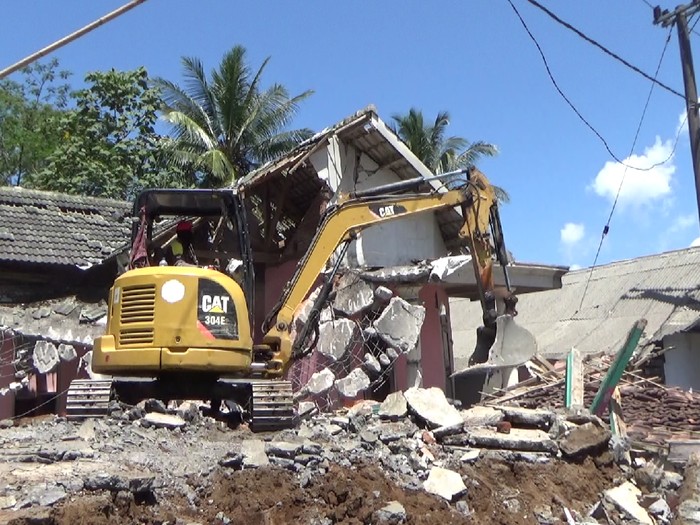 Pembersihan puing bangunan rumah warga yang rusak akibat gempa magnitudo 6,1, terus dilakukan. Satu unit alat berat dikerahkan ke desa Kali Uling, Kecamatan Tempursari, Lumajang.