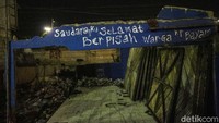 Coretan perpisahan dari warga Kampung Bayam menghiasi dinding bangunan.