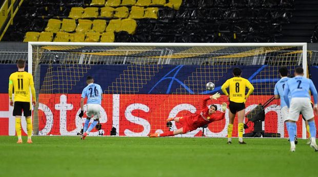 DORTMUND, GERMANY - APRIL 14: Riyad Mahrez of Manchester City scores their side's first goal past Marwin Hitz of Borussia Dortmund from the penalty spot during the UEFA Champions League Quarter Final Second Leg match between Borussia Dortmund and Manchester City at Signal Iduna Park on April 14, 2021 in Dortmund, Germany. Sporting stadiums around Germany remain under strict restrictions due to the Coronavirus Pandemic as Government social distancing laws prohibit fans inside venues resulting in games being played behind closed doors.  (Photo by Frederic Scheidemann/Getty Images)