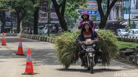 Pembonceng duduk di atas rumput yang berada di kendaraan roda dua di Depok, Jawa Barat, Kamis (15/4/2021).