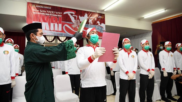 NAPI TERORISME IKRAR SETIA KEPADA NKRI Narapidana tindak pidana teorisme mencium bendera Merah Putih usai mengucap ikrar setia kepada Negara Kesatuan Republik Indonesia (NKRI) di Aula Sahardjo, Lapas Narkotika Kelas IIA Gunung Sindur, Kabupaten Bogor, Jawa Barat, Kamis (15/4/2021). Sebanyak 34 narapidana tindak pidana terorisme mengikuti ikrar setia kepada NKRI sebagai bentuk implementasi hasil akhir program deradikalisasi serta pengikat tekad dan semangat untuk menegaskan bersedia kembali membangun kehidupan berbangsa dan bernegara dalam bingkai NKRI. ANTARA FOTO/Humas Kemenkumham/Arf/aww.
