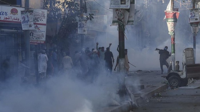 Police personnel use teargas shell to disperse supporters of Tehreek-e-Labbaik Pakistan (TLP) party during a protest against the arrest of their leader as he was demanding the expulsion of the French ambassador over depictions of Prophet Muhammad, in Karachi on April 13, 2021. (Photo by Asif HASSAN / AFP)
