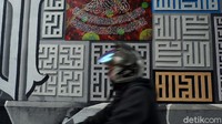 Seorang pengendara melewati tembok gang yang dihiasi kaligrafi di Gang Raden Jibja, Cicaheum, Kecamatan Kiaracondong, Kota Bandung.  