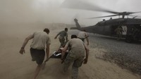 Marinir bergegas membawa rekannya yang telah ditembak di bagian dada ke helikopter penyelamat yang menunggu.  