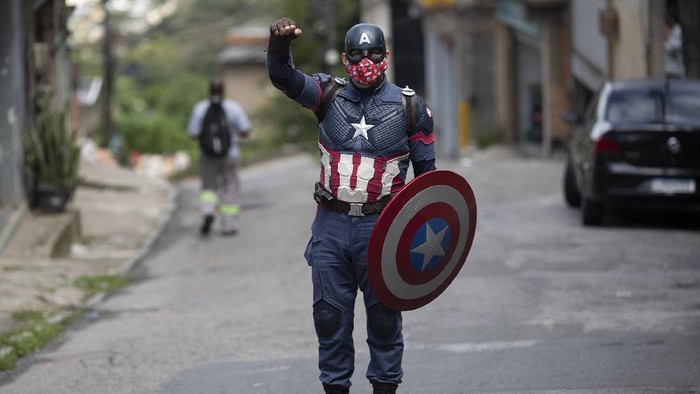 Aksi Captain Amerika Lindungi Anak-anak dari Corona Military police offcier Everaldo Pinto, dressed as superhero Captain America, rides his motorcycle amid the COVID-19 pandemic in Petropolis, Rio de Janeiro state, Brazil, Thursday, April 15, 2021. Using his own resources, Pinto advises children on the need to protect themselves against COVID-19, distributing kits equipped with cleaning products and protective face masks to prevent the spread of the new coronavirus. (AP Photo/Silvia Izquierdo)