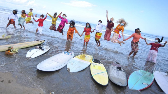 Peselancar wanita yang mengenakan busana kebaya berselancar di Pantai Kuta, Badung, Bali, Jumat (16/4/2021). Kegiatan yang diikuti puluhan perempuan termasuk sejumlah WNA tersebut dilakukan untuk menyambut peringatan Hari Kartini serta membangkitkan sektor pariwisata Bali yang terdampak pandemi COVID-19. ANTARA FOTO/Fikri Yusuf/wsj.