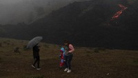 Orang-orang berjalan di dekat aliran lava dari Gunung Berapi Pacaya di San Vicente Pacaya, Guatemala, Kamis (15/4/2021) waktu setempat.  