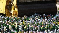 Ribuan botol minuman keras dimusnahkan dengan cara digilas alat berat.