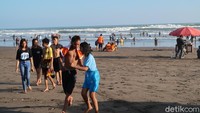 Dari pantauan detikTravel, tampak beberapa orang wisatawan tanpa mengenakan masker tengah bermain air dengan riang gembira. Sedangkan wisatawan yang duduk di pinggir pantai sebagian besar tidak mengenakan masker. (Pradito Rida Pertana/detikTravel)