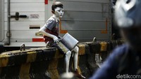 Seorang anak menjadi manusia silver untuk mengais rupiah.