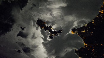 Seorang astronaut di ISS mengambil foto di perairan Mediterania dan beberapa pulau dan kota di pesisir Italia. Bagian abu-abu yang mendominasi foto adalah pantulan cahaya Bulan di permukaan laut atau yang dikenal sebagai moonglint. Foto: NASA