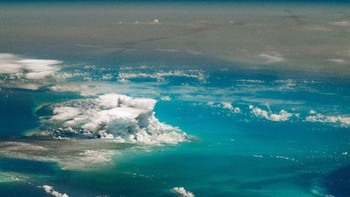 Foto yang dijepret oleh astronaut Chris Cassidy pada 23 Juni 2020 ini menampilkan awan badai di atas Pulau Andros di Kepulauan Bahama. Bayangan cokelat di sebelah kanannya adalah debu dari Gurun Sahara. Foto: NASA