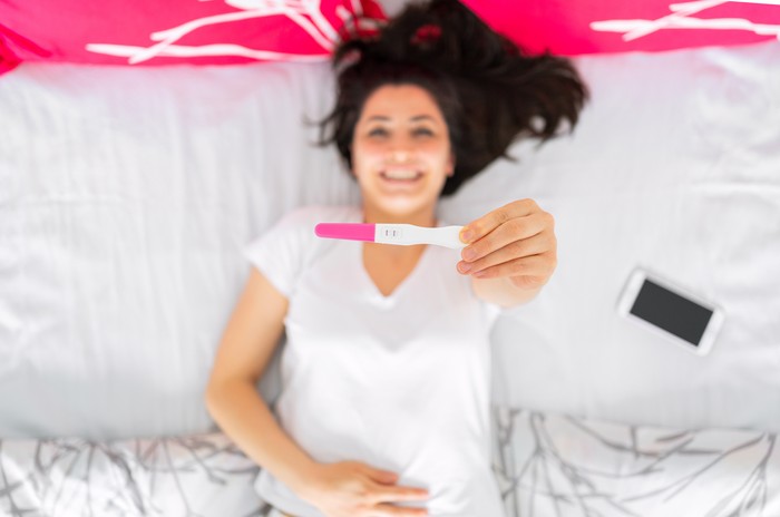 Ilustrasi wanita hamil Excited woman with positive pregnancy test. Celebrating positive pregnancy test result. Yes, I am pregnant